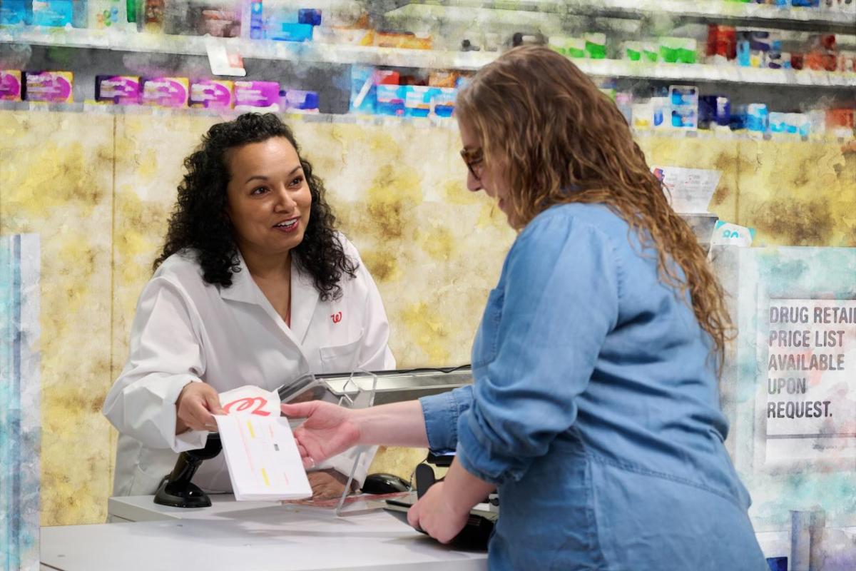 A pharmacist handing over a prescription over the counter 