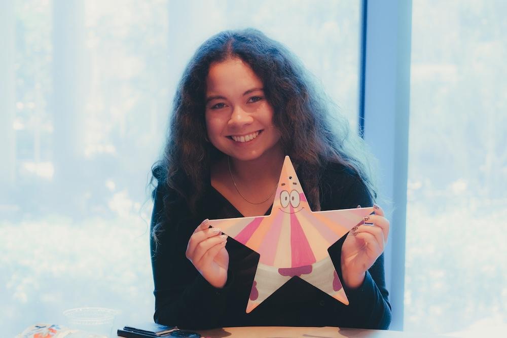 Young woman holding up painted star