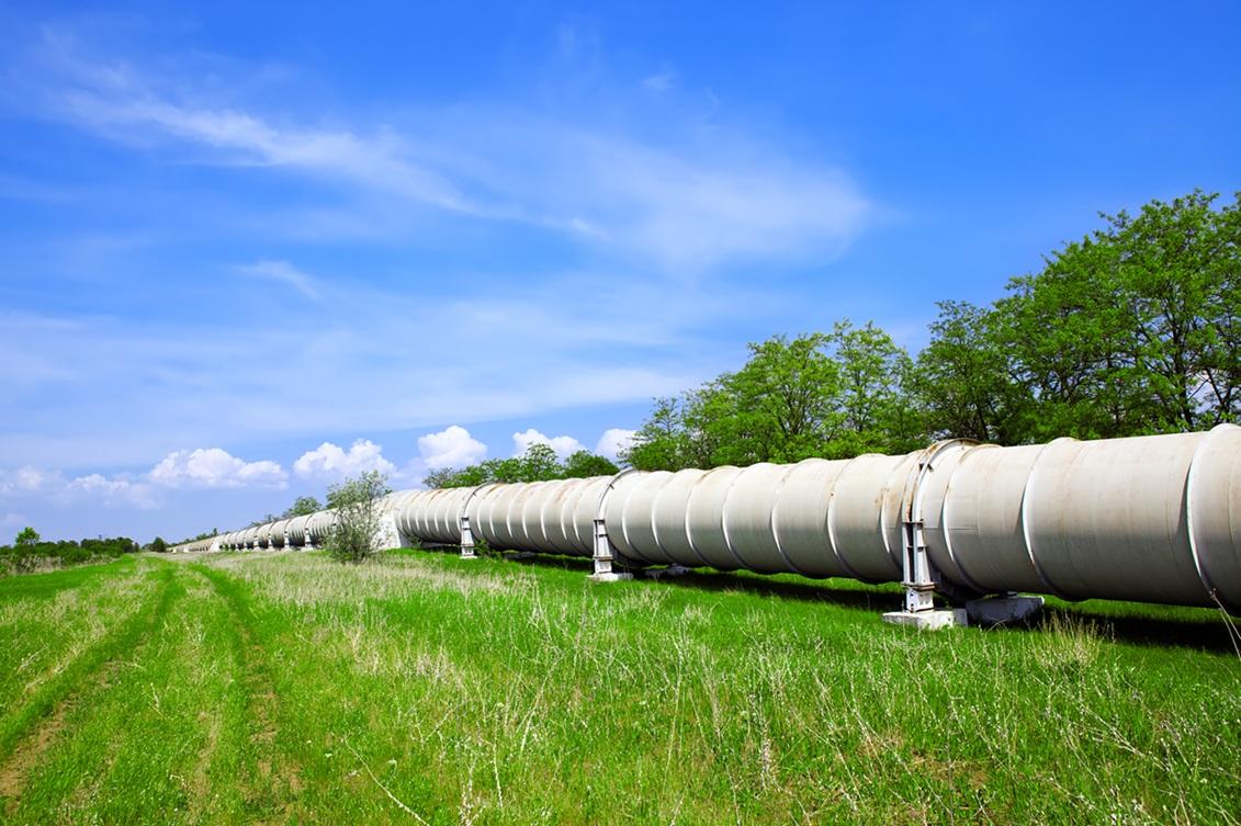 Pipeline in a grassy field with a blue sky