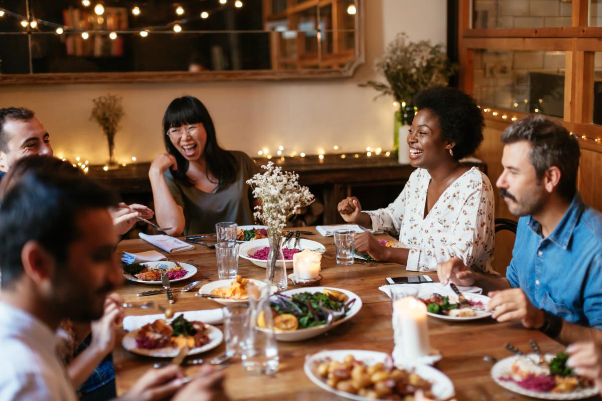 group of people laughing and talking over dinner