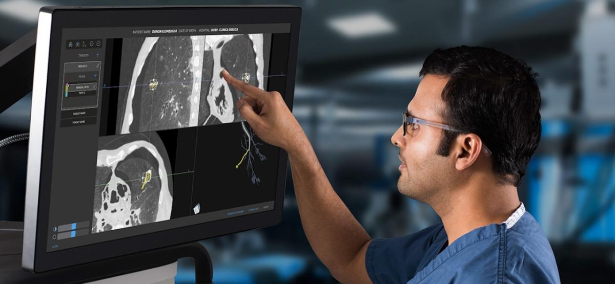person looking and pointing at computer screen