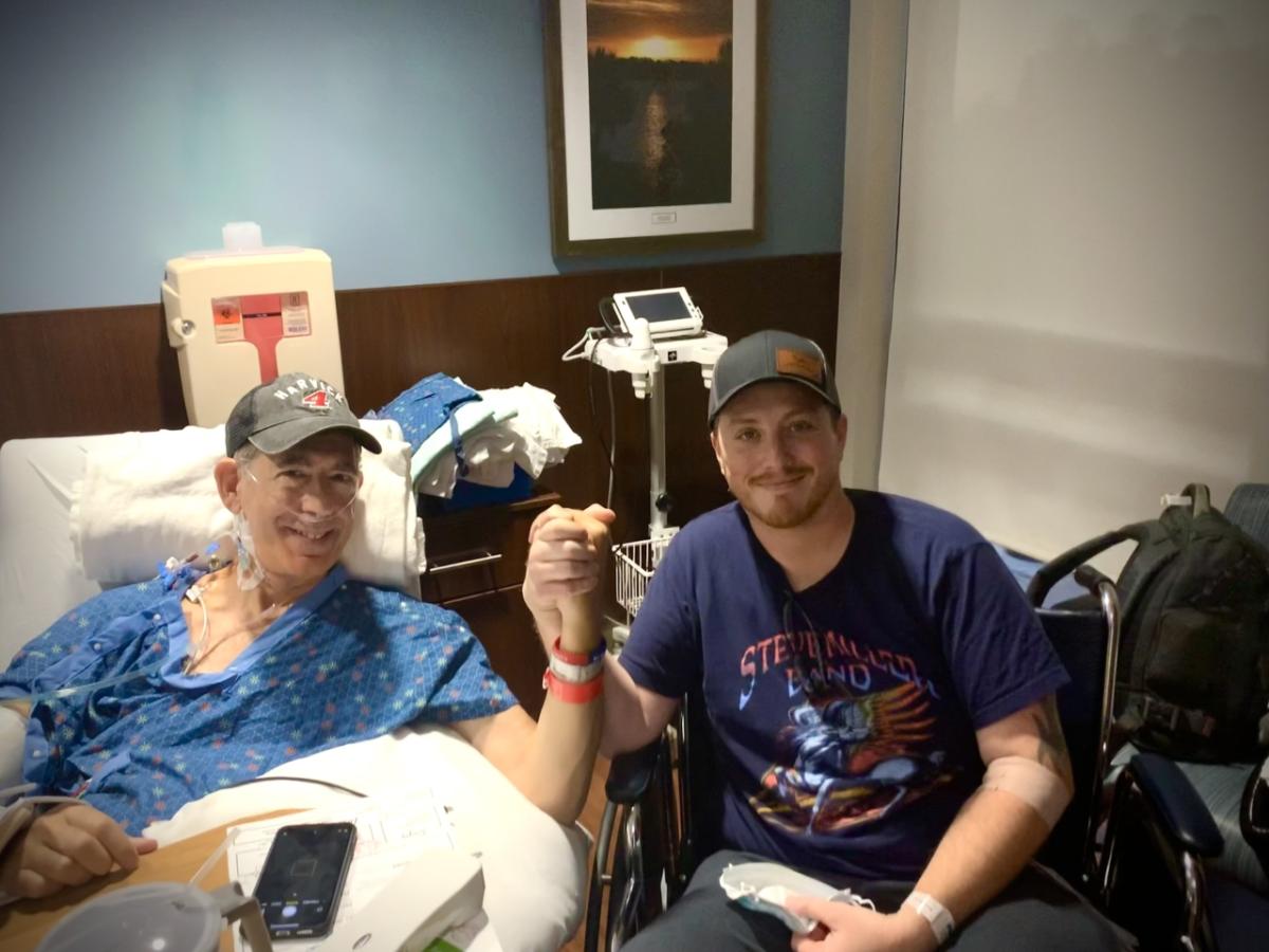 Two people clasping hands from a hospital bed