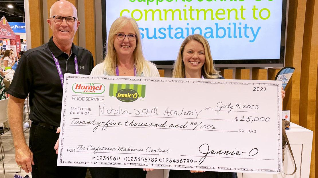 Three people holding a large check from Jennie O.