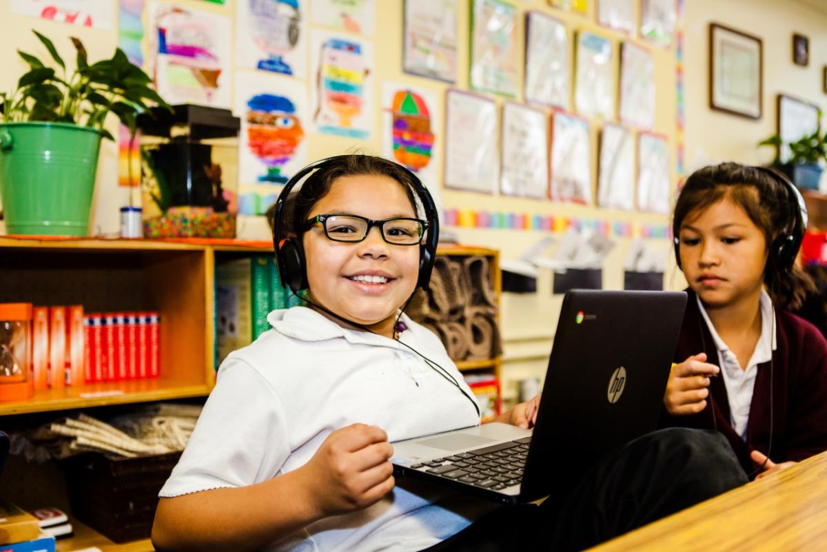 Photo credit: New Teacher Center Child with headset using laptop