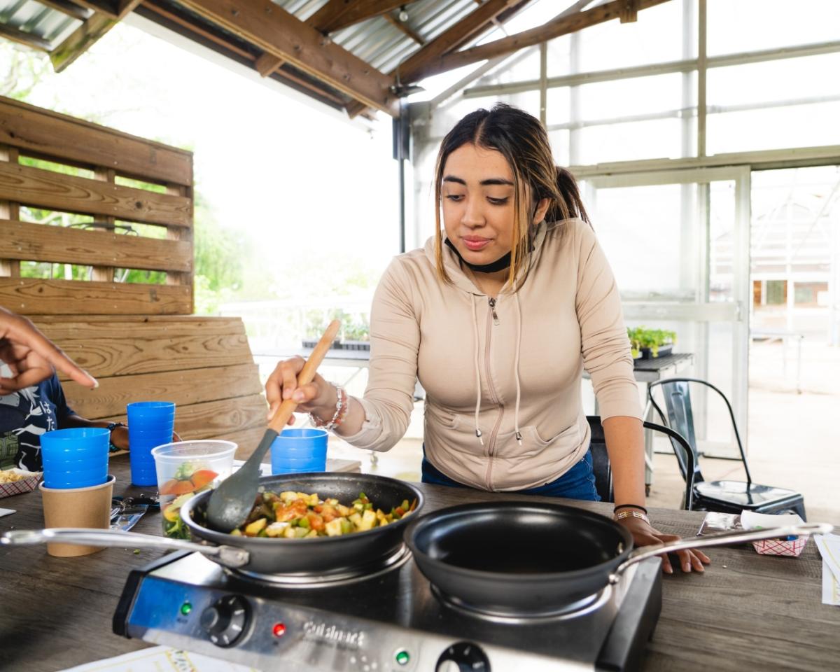 A person cooking at Jones Valley Teaching Farm