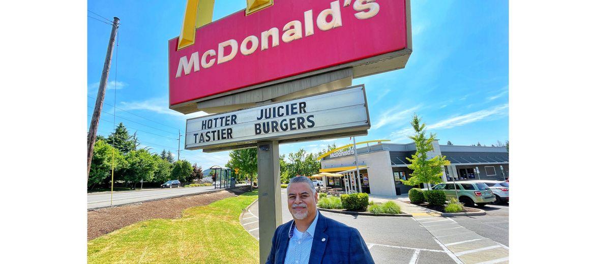 Juan Marquez outside by a McDonalds restaurant sign.