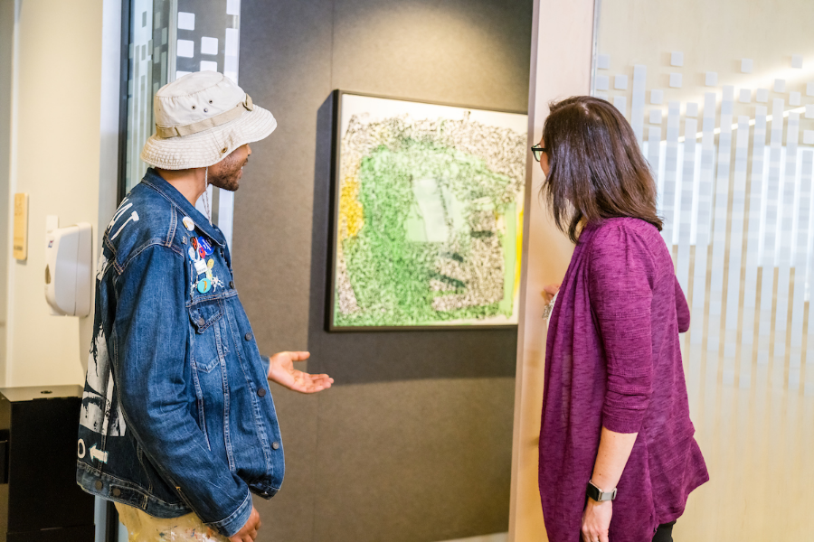 Two people looking at art on the wall