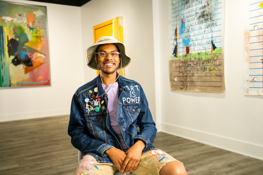 Person sat in a room surrounded by art on the wall