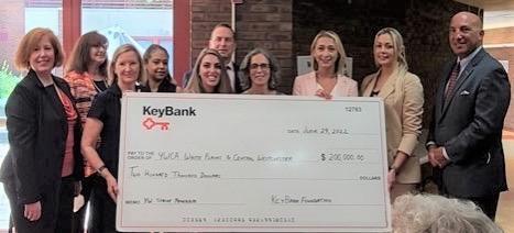 Group of people hold a large KeyBank check