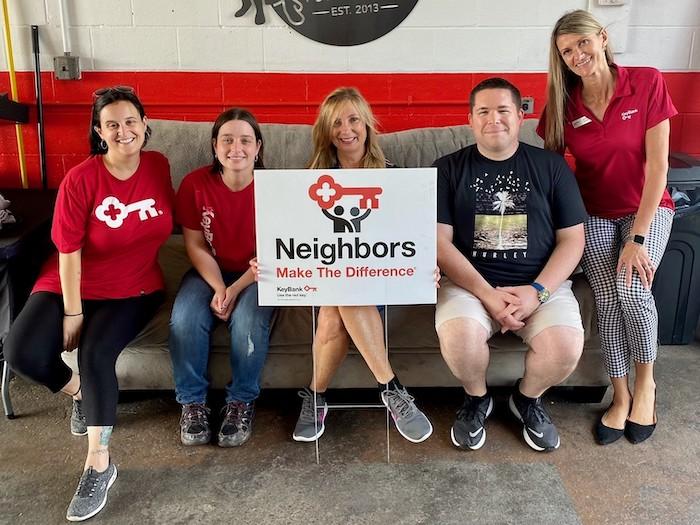 KeyBank volunteers holding a neighbors make the difference sign.