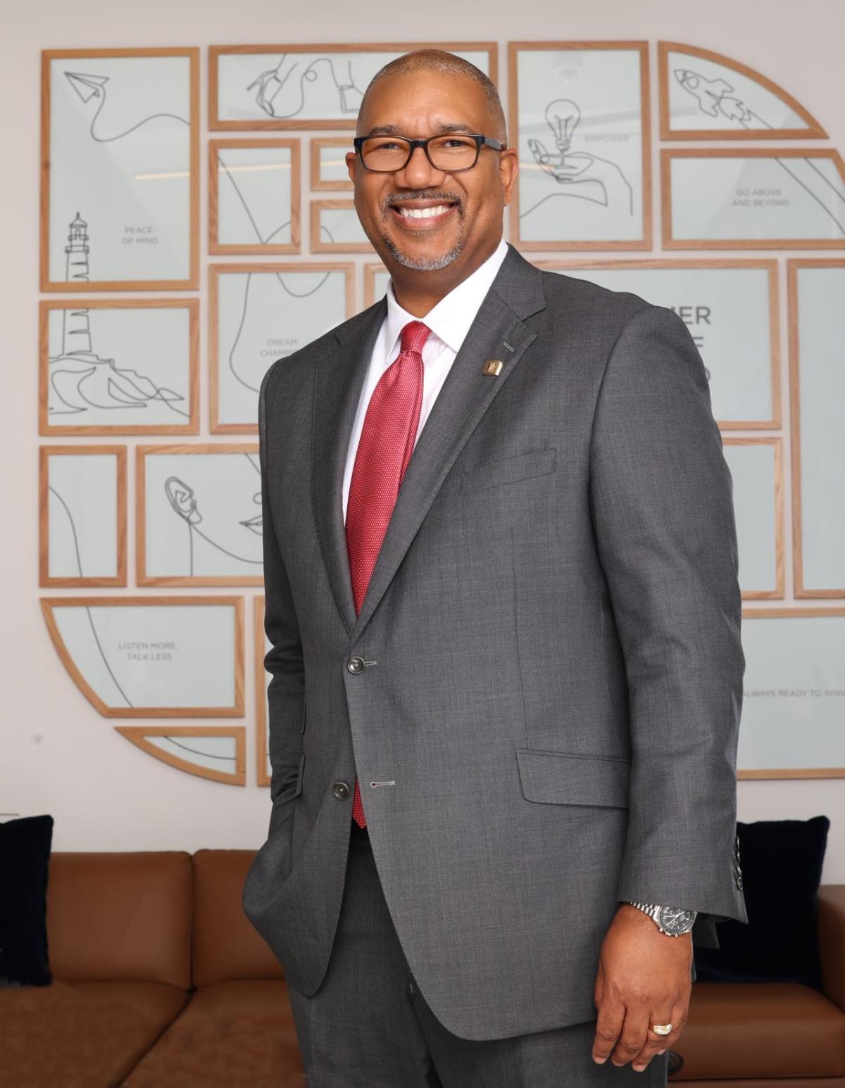 Kala Gibson, executive vice president and chief corporate responsibility officer leads community development banking, community impact banking, inclusion and supplier diversity, corporate sustainability and philanthropy at Fifth Third Bank. Kala Gibson stood smiling, wearing a grey suit and red tie