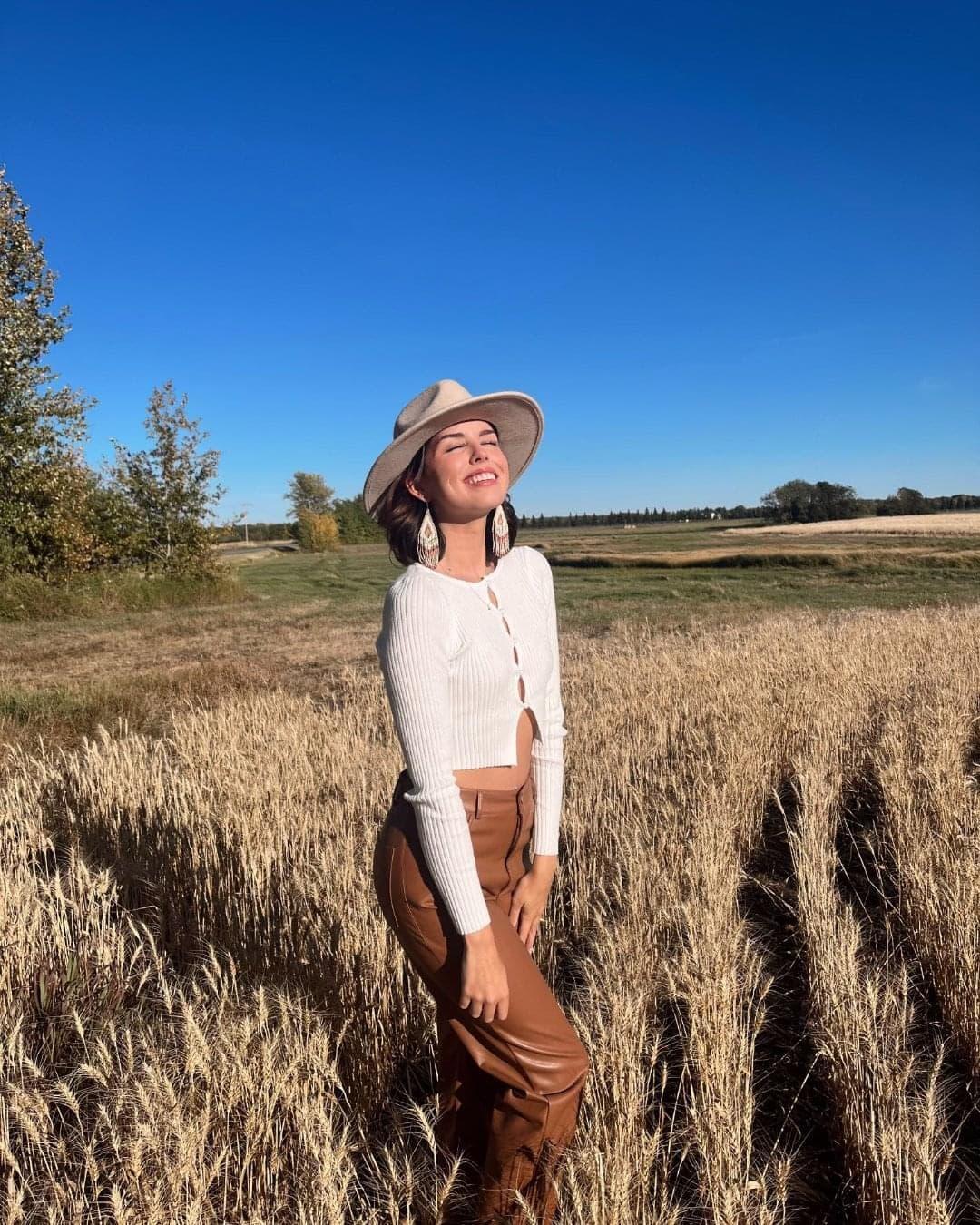 For Kaylee Welsh, receiving a Belcourt Brosseau Métis Award was more than just financial support for university—it was a key step on her journey to discover her family’s culture and history. Kaylee Welsh standing in a crop field, eyes closed, smiling toward the sun