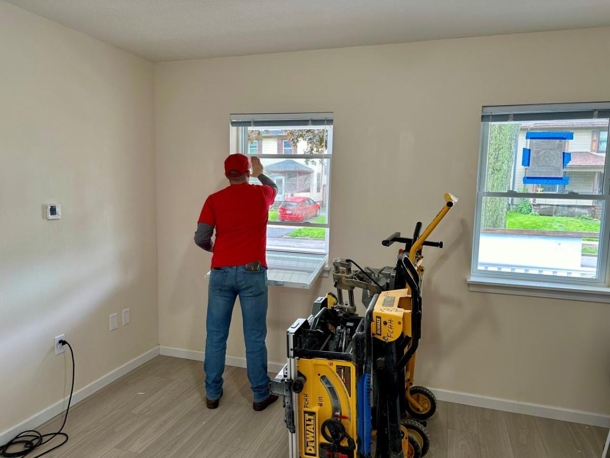 Habitat for Humanity team member installing windows.