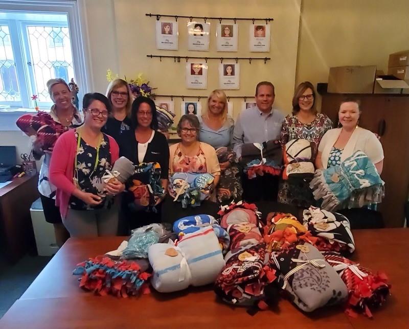 KeyBank volunteers pictured with blankets that they have assembled.