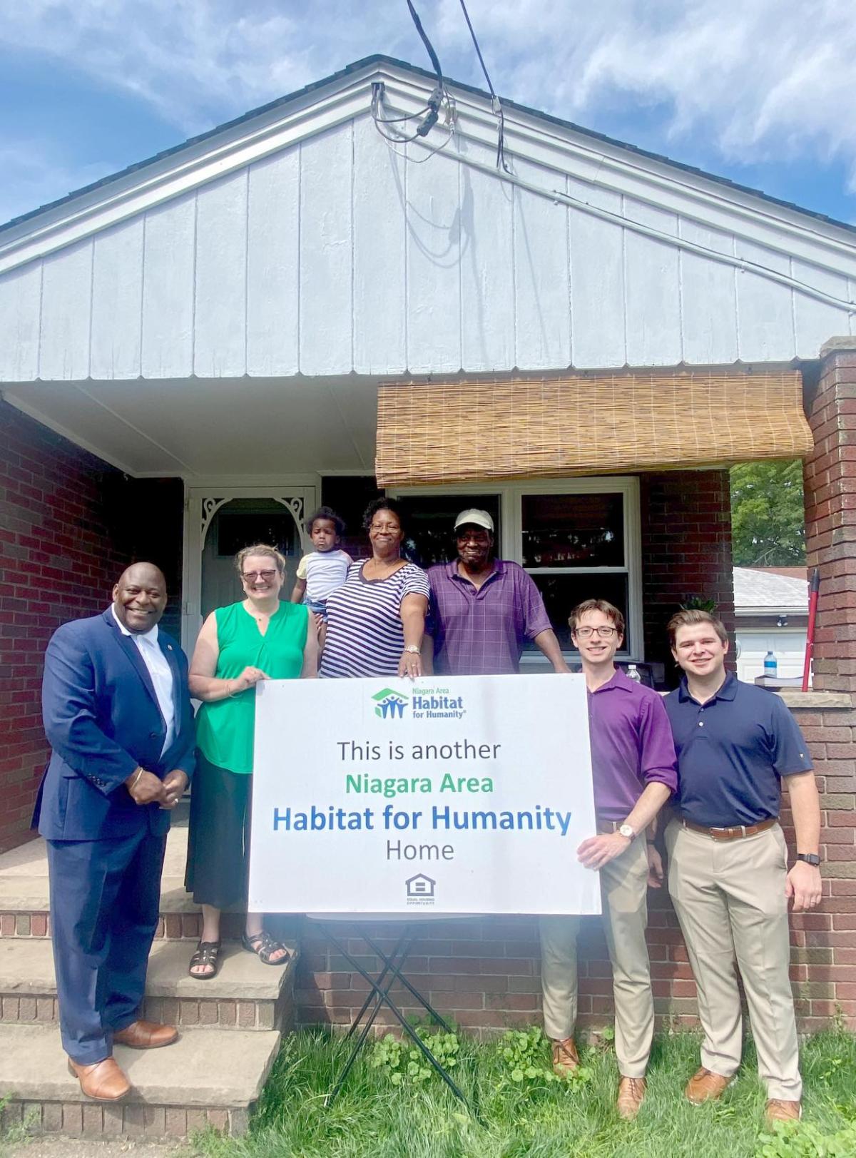 KeyBank and Habitat for Humanity team members shown in front of a home.