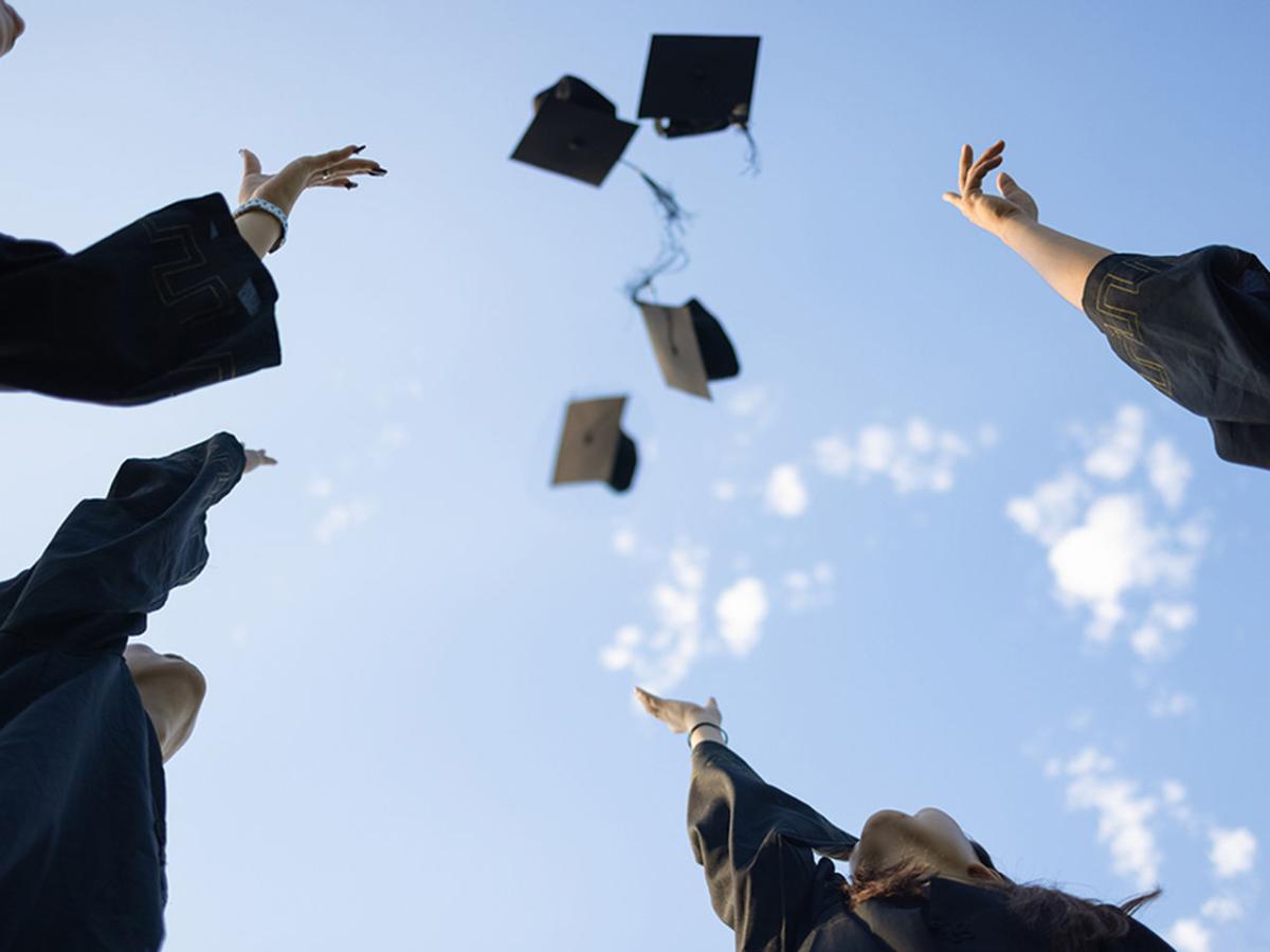 graduates throwing caps in the air