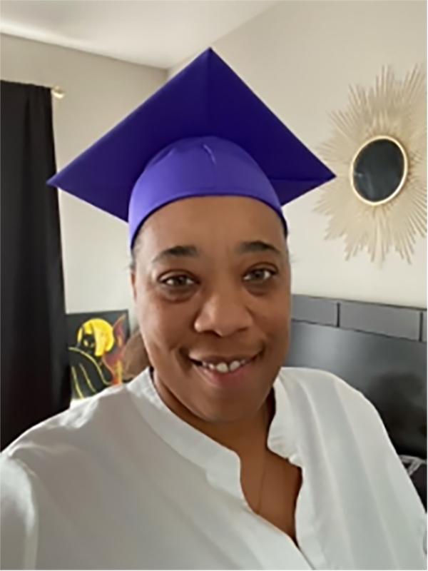 Kim E. in a graduation cap