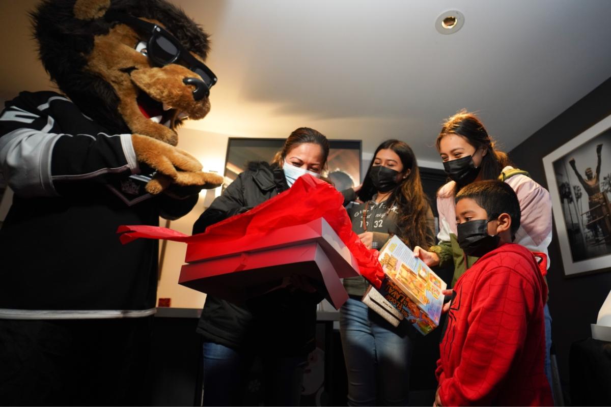 LA Kings mascot Bailey unwraps presents with families in the arena suite at Crypto.com Arena (formerly STAPLES Center).