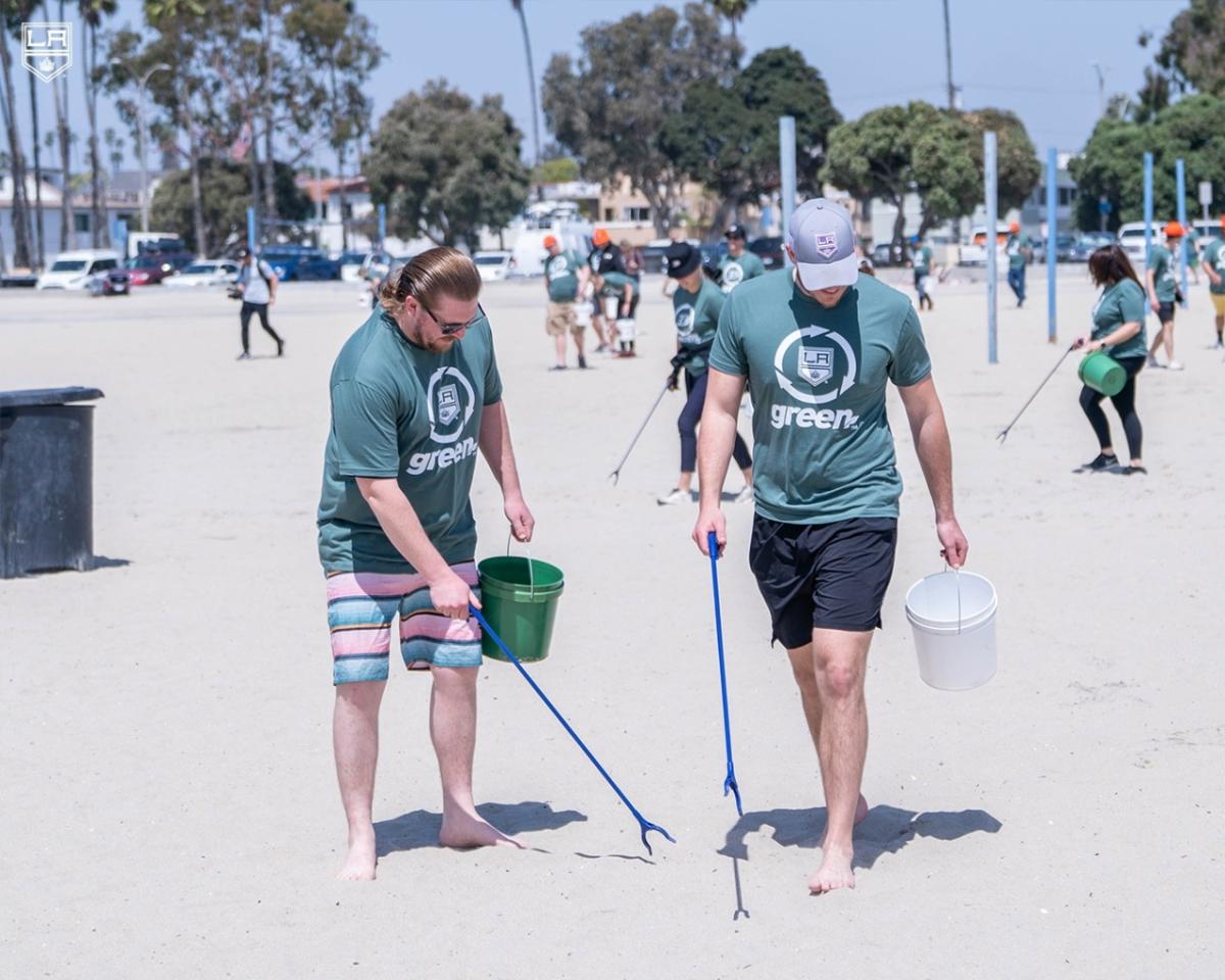 people picking up trash along a beach