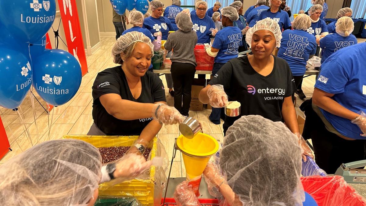 Volunteers scooping and packing food.