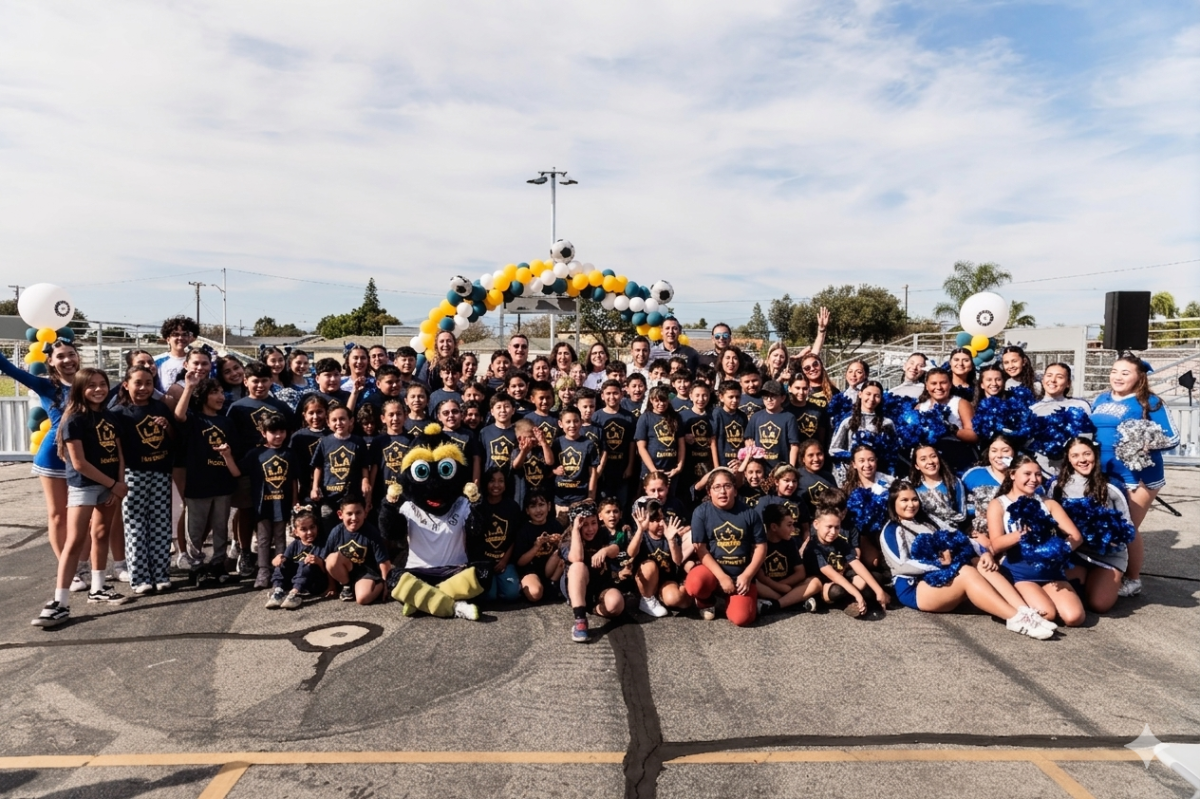 Large group photo of students, staff, and LA Galaxy representatives on the new court.