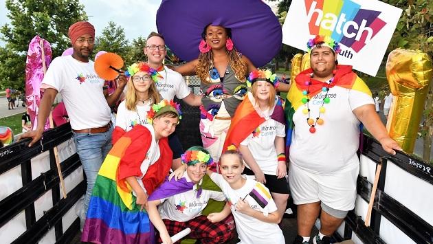 children and adults in rainbow clothing