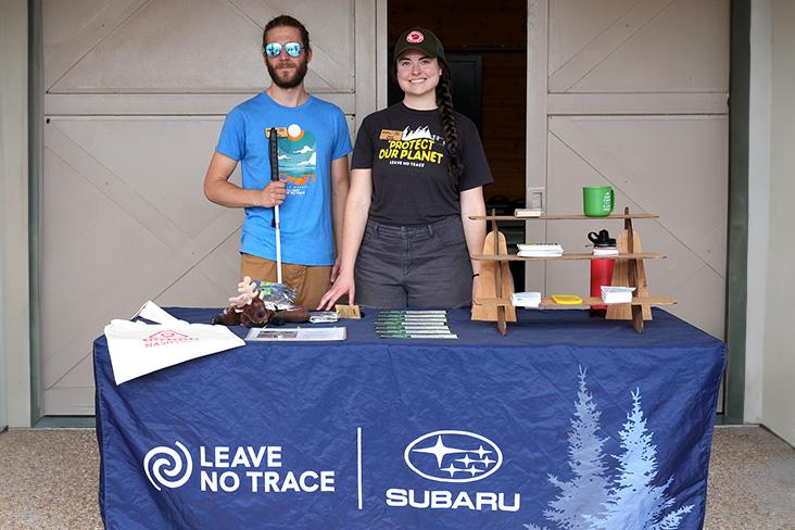 Two people stood behind an event table 