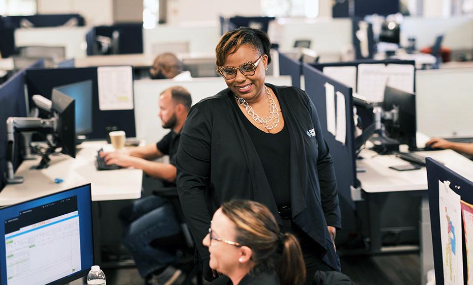 LaQuitta Ghent in an office setting, smiling at another.