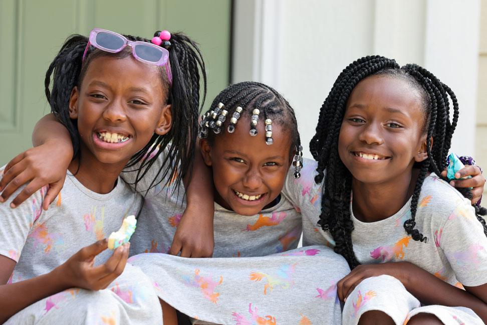 Three of Latonya's daughters in matching outfits smiling