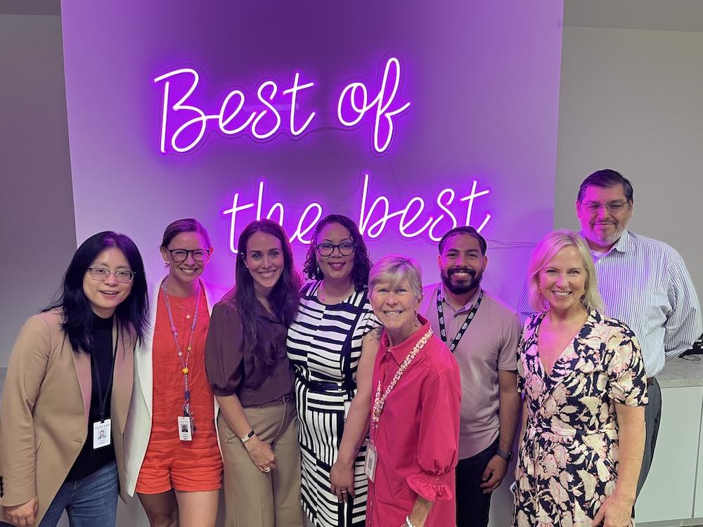 Group photo in front of sign reading "Best of the best"
