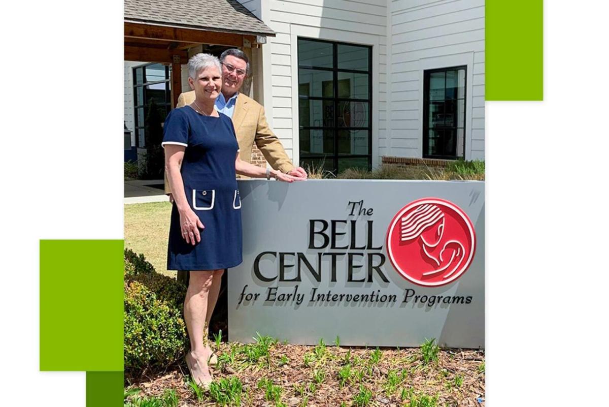 Lee and Jeff Taylor in front of a sign for "The Bell Center"