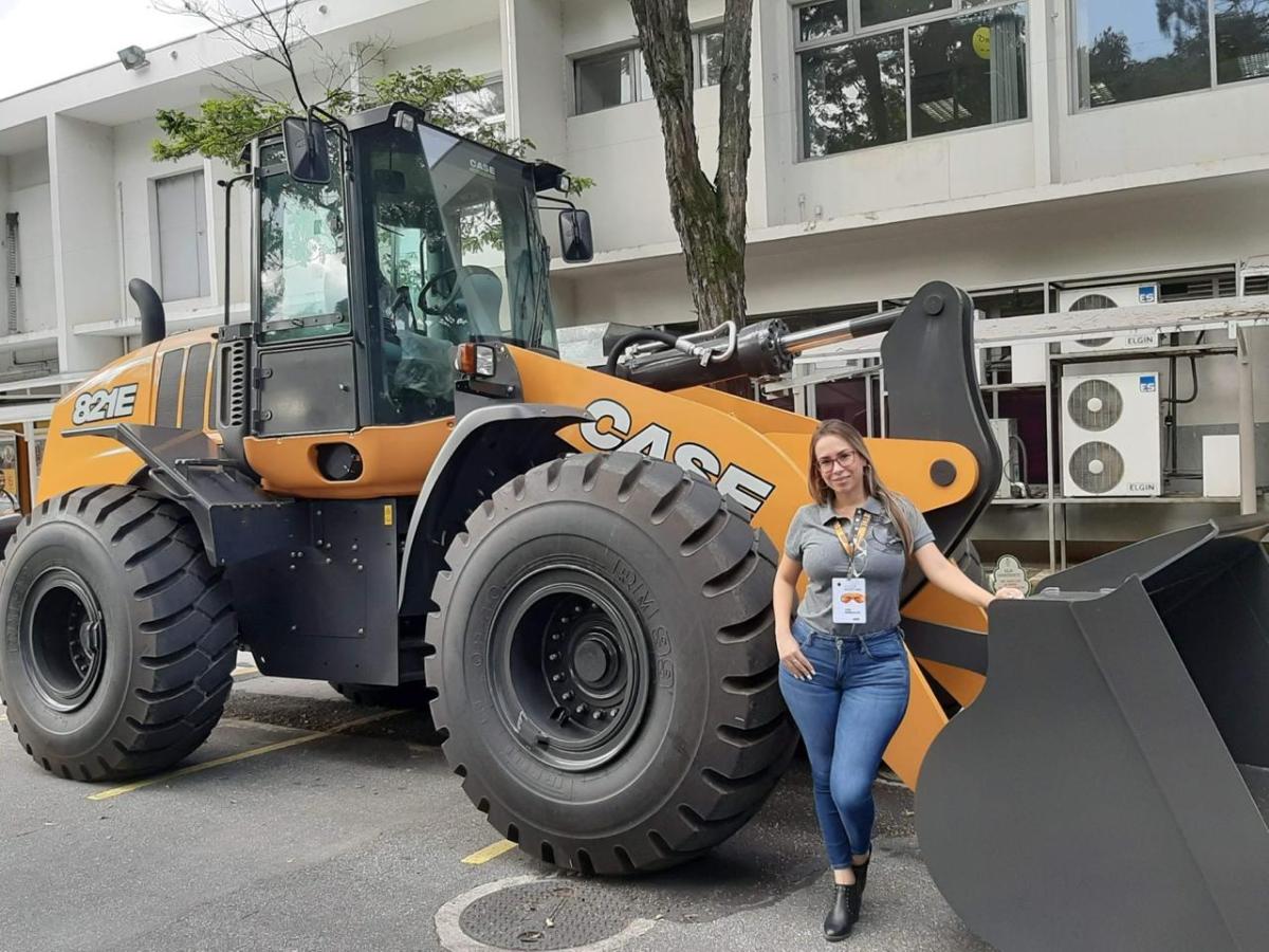 A person stood in front of agricultural machinery 