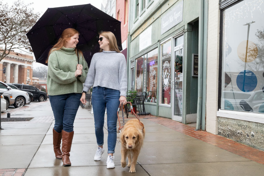 Lindsey Chambers walking with someone else and a service dog