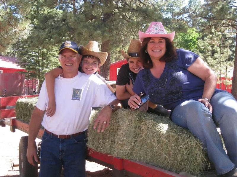 Lori and her family shown at a farm on a hayride.