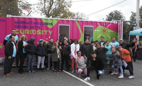 MilliporeSigma's mobile science lab, the Curiosity Cube, visits the Moody Elementary School in Lowell. Fifth-graders pose for a group photo after exploring inside. SUN/Julia Malakie