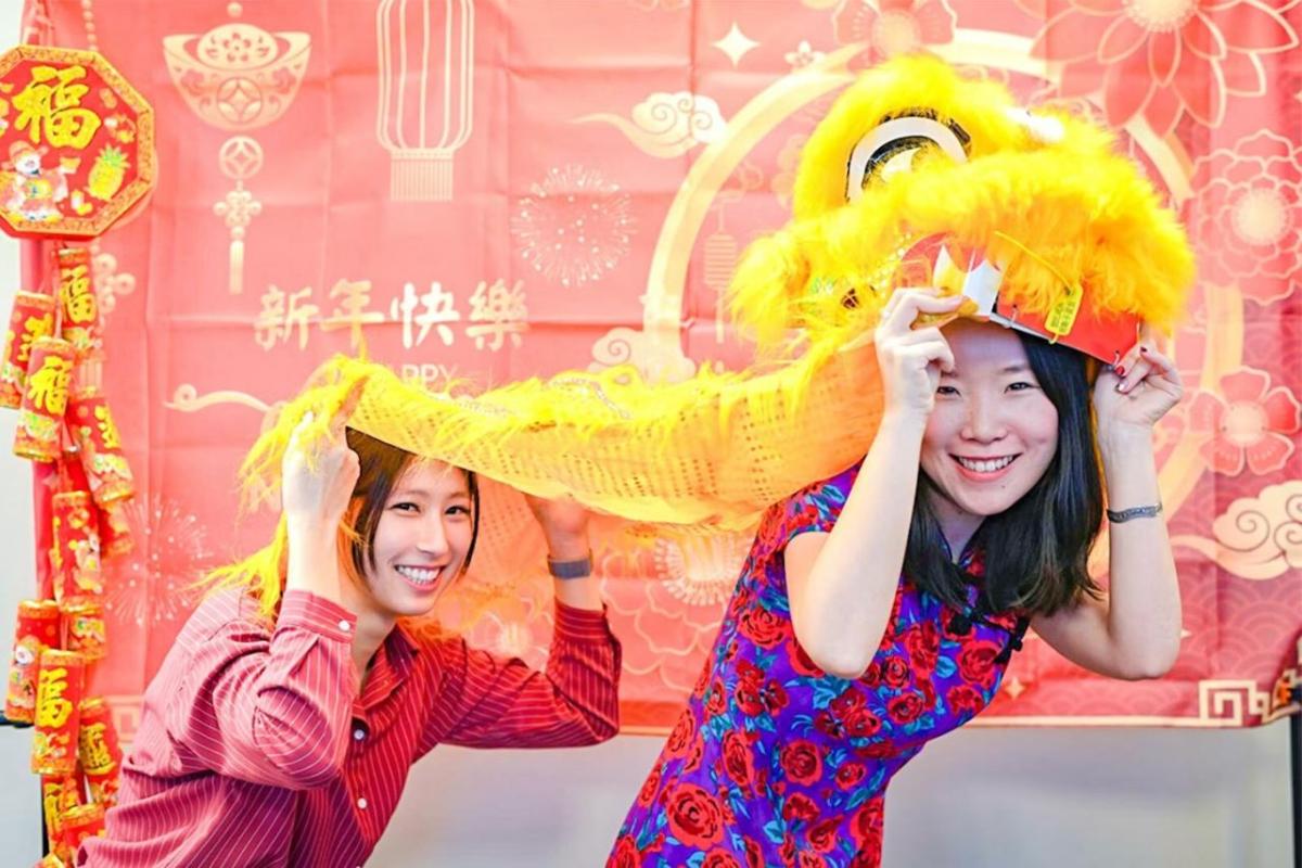 Two people holding a lion dance costume