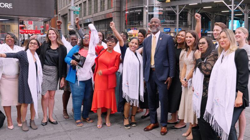 Group of people pose outside of the NASDAQ building