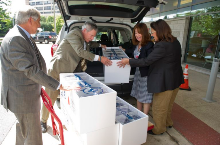 Lou DeGennaro, PhD, President and CEO & Lymphoma Society; Thomas J. Doll, President and CEO, Subaru of America; Adrienne Kirby, PhD, FACHE, Executive Chair and CEO, Cooper University Health Care; and Generosa Grana, MD, FACP, Director, MD Anderson Cancer Center at Cooper, unload a vehicle full of blankets to be delivered to patients.