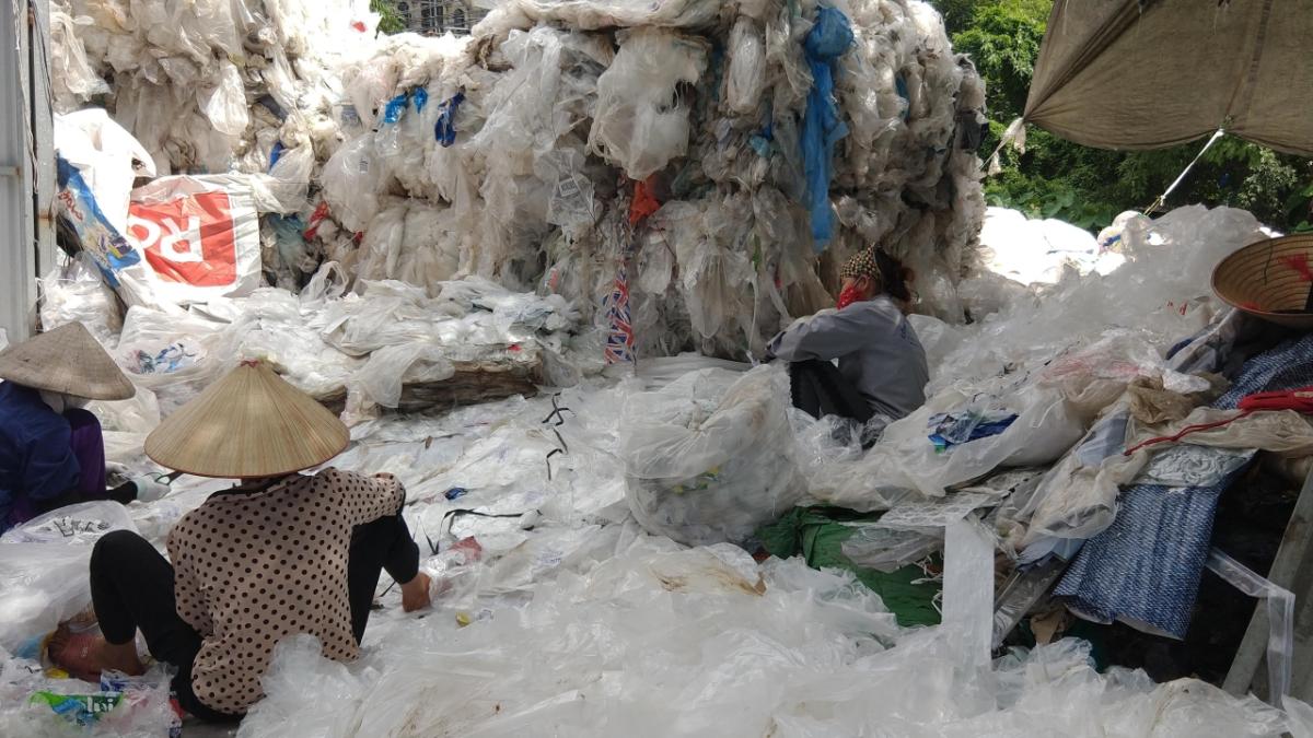 Women removing bar codes and stickers by hand from clear film plastics imported from Europe at an informal recycling village outside of Hanoi, Vietnam. Source: Dr. Jenna Jambeck