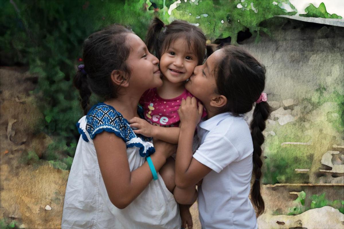 young girls hugging and kissing cheeks