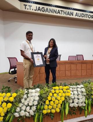 Two people on a stage holding a plaque.