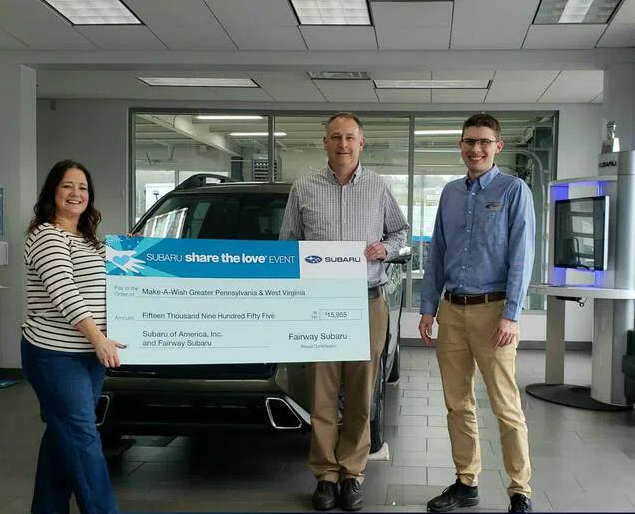 Shown from left are: Maggie O’Brien, regional manager of Make-A-Wish; Al Corazza, general manager, Fairway Subaru; and Aaron Meijer, sales manager, Fairway Subaru. Image courtesy of Times Leader Three people holding donation check in front of car in showroom