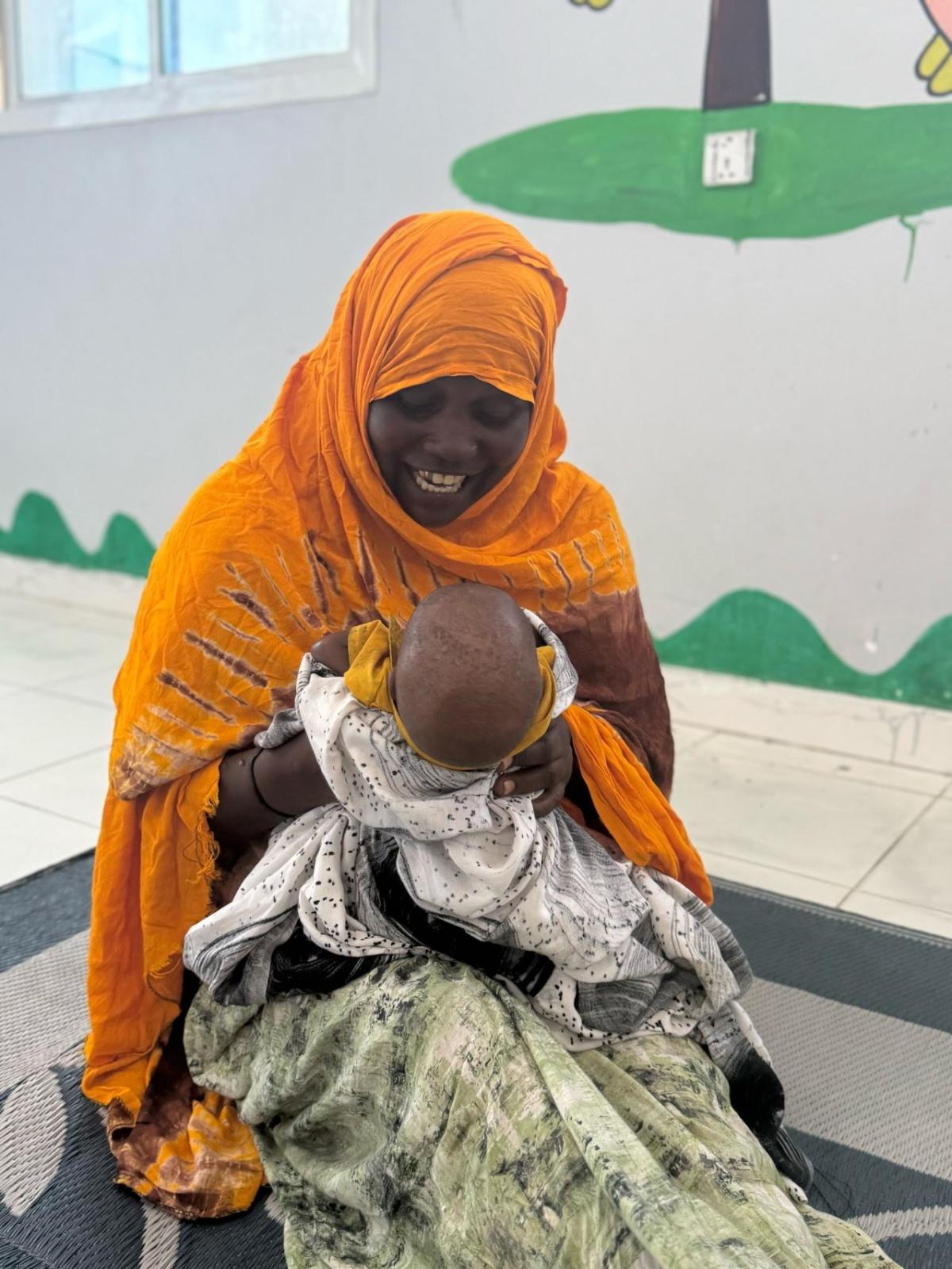 Maria plays with her grandson at the stabilization center. 