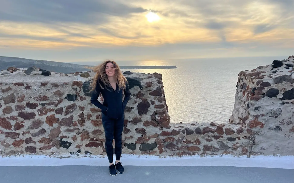 Mandy shown by a stone wall overlooking the ocean.