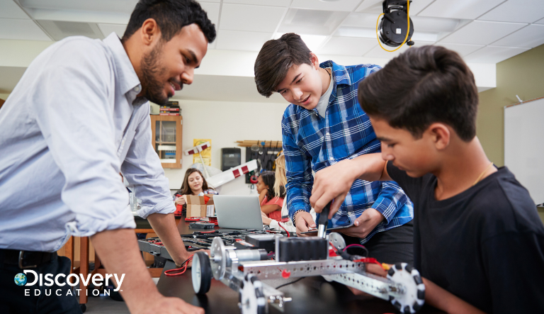 Student working with teacher on building a machine