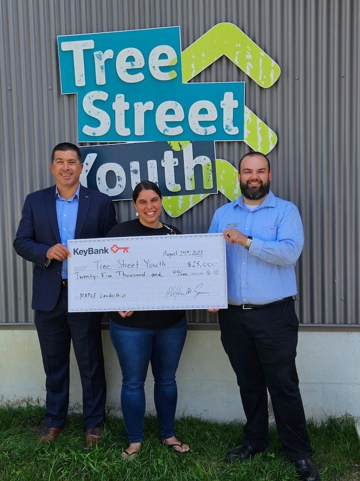 Maine Tree Street Youth team leaders with KeyBank market rep shown holding a grant check.