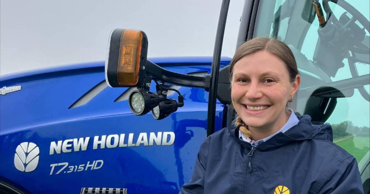 Melody Labinsky outside in front of a large tractor.