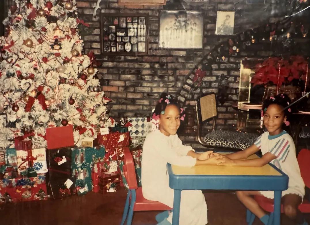 Meshawn Woods and LeShawn Parrish as kids by a christmas tree.
