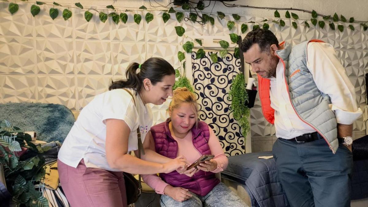 Brenda and two others, looking at a smartphone together