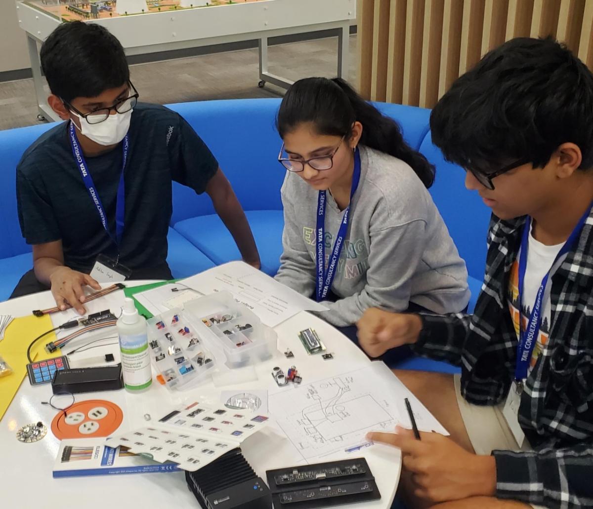 three students sitting and working together 